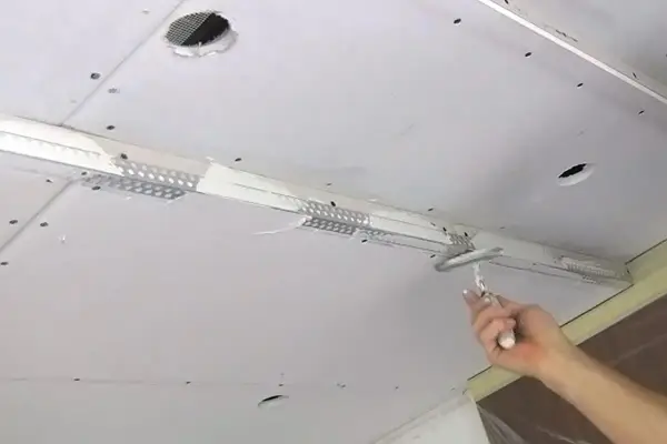 Hand spachtelt Rigipsdecke, um eine glatte Oberfläche für den Innenausbau zu schaffen.
